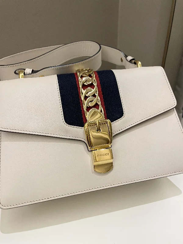 Women Gucci Sylvie bags with a monogram - embossed leatherGucci Sylvie Chain Bag Ivory Calfskin